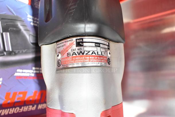 Milwaukee Electric Sawzall with a metal label showing serial number and safety warnings, in a tool box.