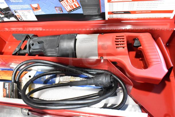 Milwaukee Electric Sawzall in red tool box, visible power cord and manual. Includes original packaging and accessories.