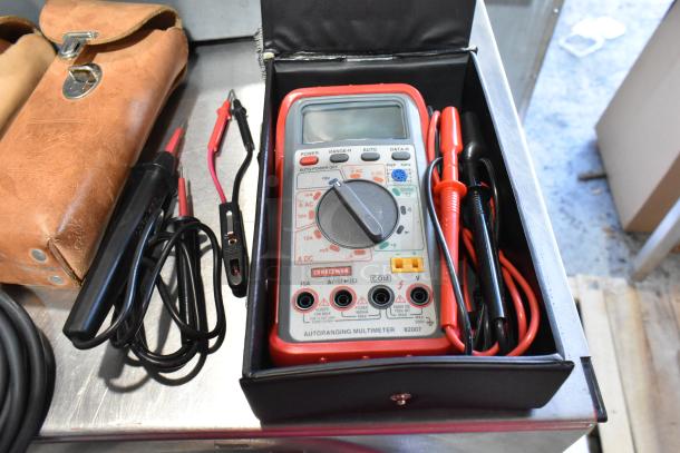 Gray poly tool box with contents including a Craftsman autoranging multimeter, red and black probes, and accessories in good condition.