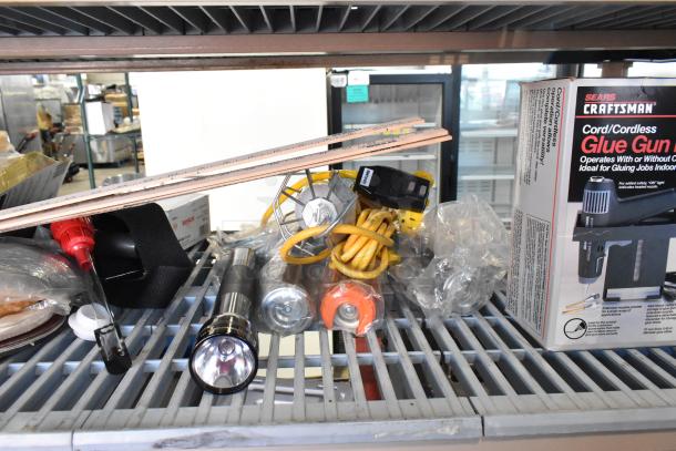 Tiered lot including Craftsman glue gun kit, flashlight, worklight, ruler, and extension cord. Items appear new in packaging.