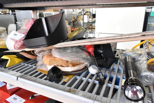 Tiered shelf with various tools including a glue gun kit, flashlight, and work light. Items are in mixed condition.