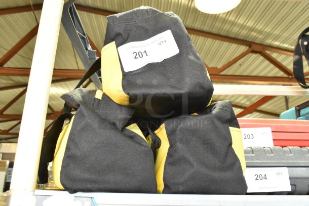 Three black and yellow bags labeled "201" containing dusting brush, kneepads, in good condition, auction item.