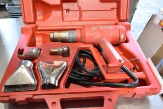 Milwaukee electric heat gun in red hard case, 120 volts, with three metal nozzles, cord, and marked controls.