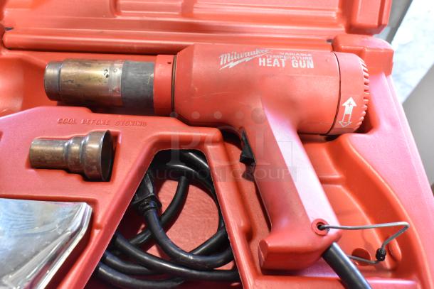 Milwaukee Electric Heat Gun in red hard case, 120 volts, features adjustable temperature settings, includes nozzle attachments.