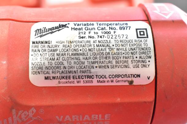 Milwaukee Electric Heat Gun, 120V, 1 Phase, model 8977 in red. Label shows temperature range 212°F to 1000°F.