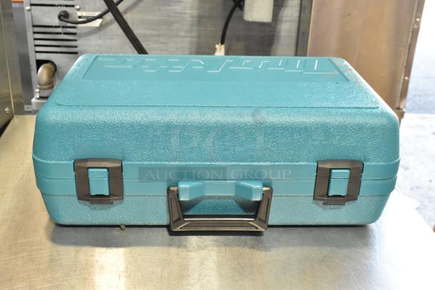 Makita 5090D circular saw in a teal hard case, showcasing sturdy latches and handle. Part of auction item set.