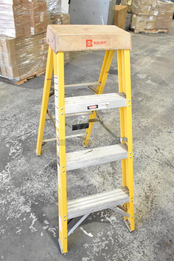 Bauer A Frame Ladder, 300 lb capacity, yellow, aluminum steps, slight wear, visible brand logo and safety labels.