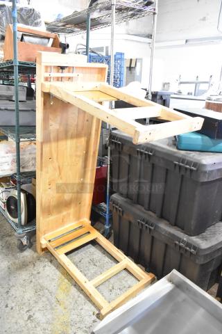 Wooden table with unfinished surface, partially assembled, showcasing a sturdy frame. Suitable for restoration or DIY projects.