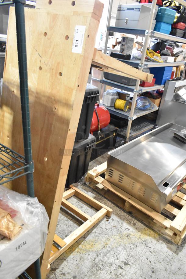 Wooden table panel with multiple evenly spaced holes, showing natural wood grain. Item tag reads "211."