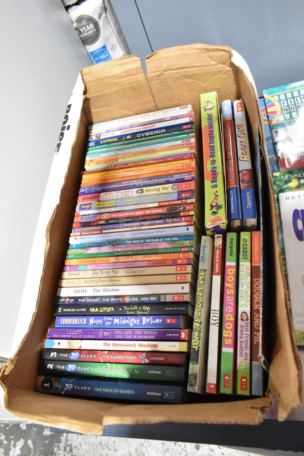 Cardboard box containing a variety of books, stacked neatly, with visible titles such as "Henry and Ribsy" and "The Witches."