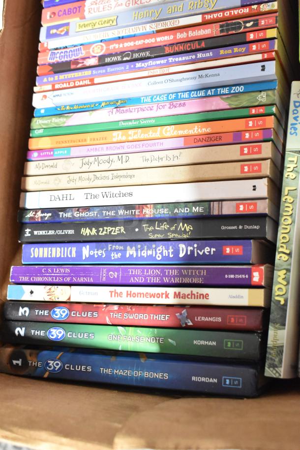 Box of assorted books featuring titles such as "The Witches" by Roald Dahl and "The Lion, the Witch and the Wardrobe" by C.S. Lewis.