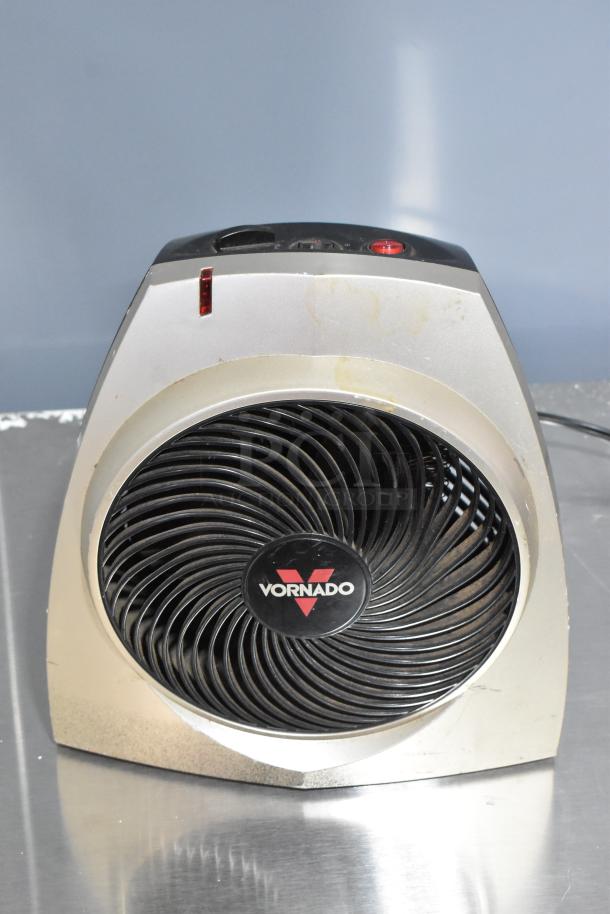 Vornado fan with visible wear, features a black grille and silver casing. Brand label centered on front.