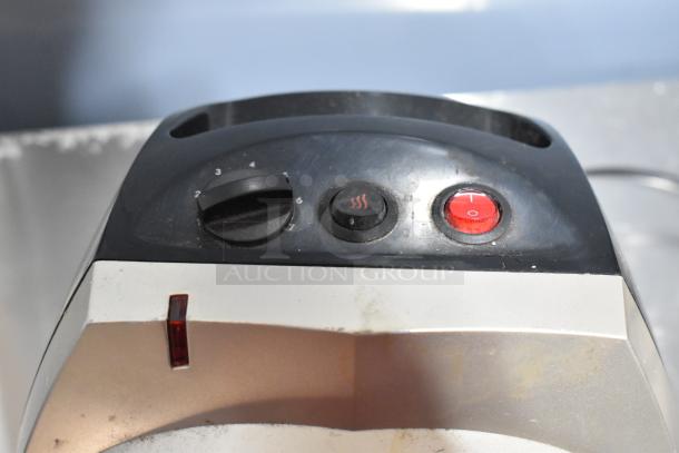 Control panel of a Vornado fan with speed dial and red power button. Fan shows signs of wear and use.