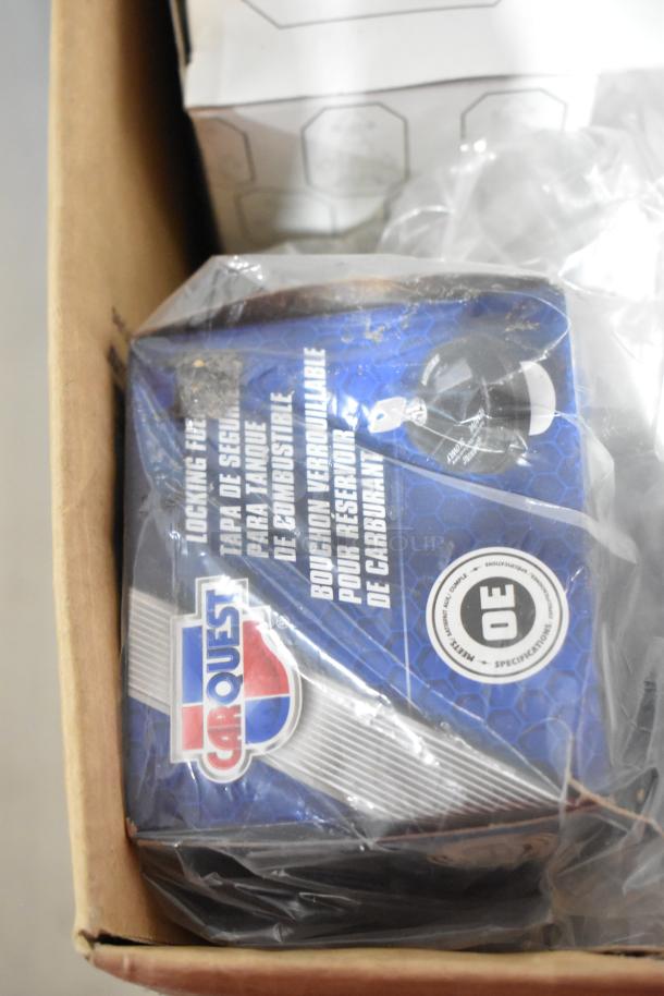 Box containing a Carquest locking gas cap visible among items in auction lot. Packaging shows "OE Specifications."