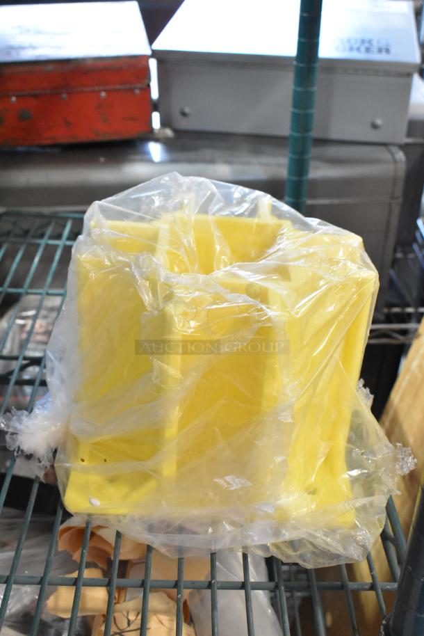 Yellow plastic mold wrapped in clear plastic on a metal shelf, part of a mixed lot with tools and accessories.