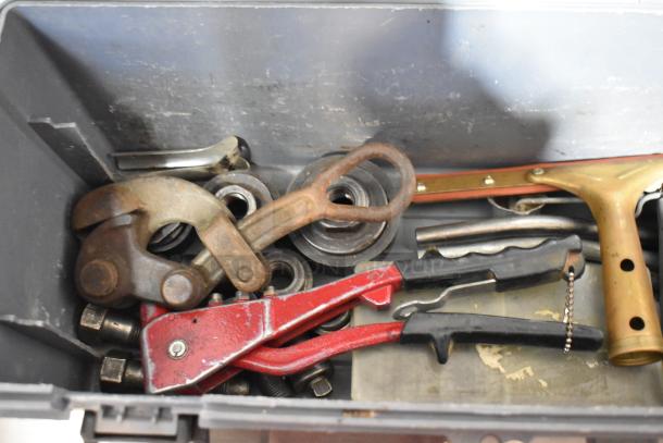 Gray poly tool box containing various tools, including a red Shur Grip. Box shows signs of use.