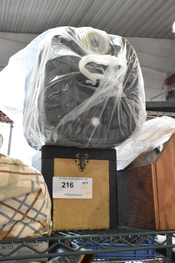 Tier lot of various items wrapped in plastic, includes a tool bag. Label reads "216, QTY Tier lot."