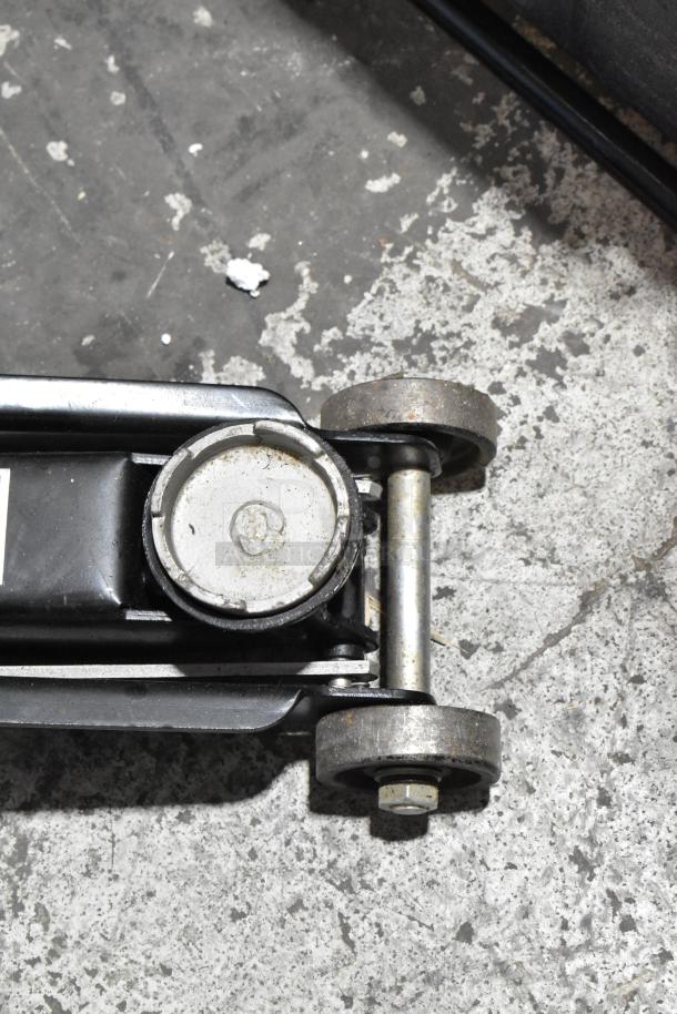 Craftsman 5,000 lb capacity hydraulic service jack, slightly used, visible wear on wheels, sturdy metal construction.