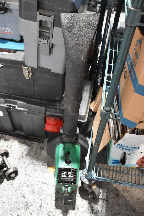 Foikl Kraft energy-efficient tool with black nozzle attachment, Craftsman hydraulic jack, and Weed Eater in storage area.