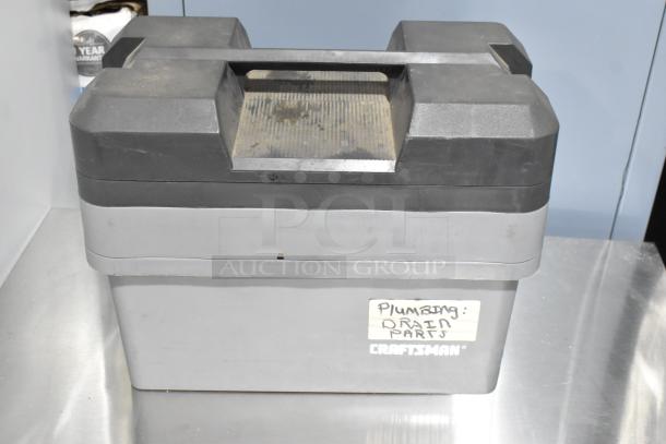 Gray poly tool box labeled "Plumbing: Drain Parts," marked "Craftsman," showing signs of wear. Includes contents.