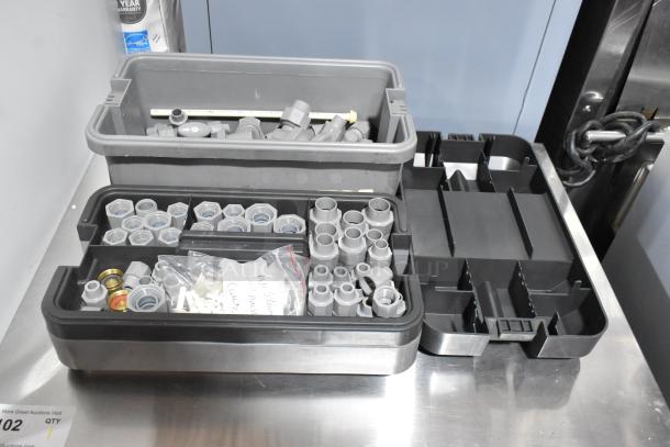 Three gray poly tool boxes with assorted fittings and components, various sizes, clean condition. Labels show content listings.
