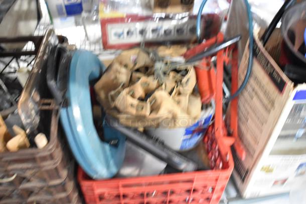 Various tools and items in a crate, including a blue ladder dolly. Mixed conditions. Some items have visible labels.