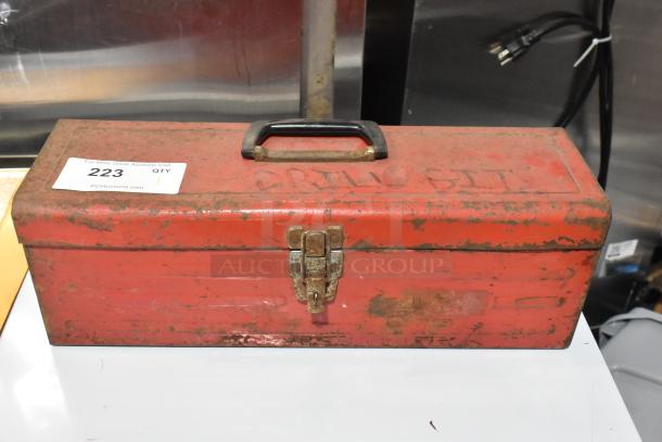 Red metal tool box with contents, visible wear and rust, black handle, latch closure, auction tag numbered 223.