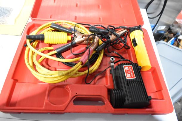 Deluxe air compressor in hard red case, includes yellow hose and clamps, appears in good condition with visible label.