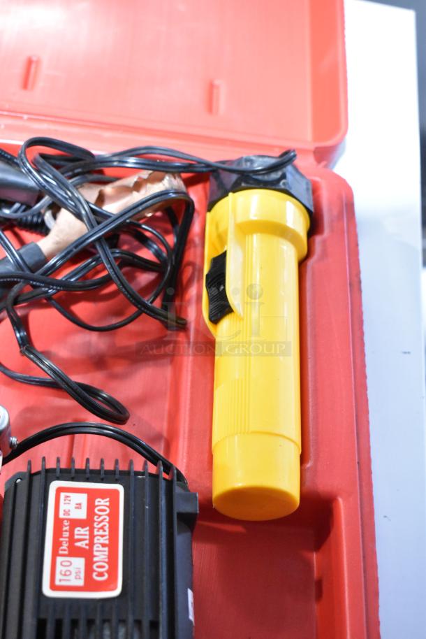 Deluxe Air Compressor in red hard case, 160 psi, 12V DC. Includes wires and yellow flashlight. Good condition.