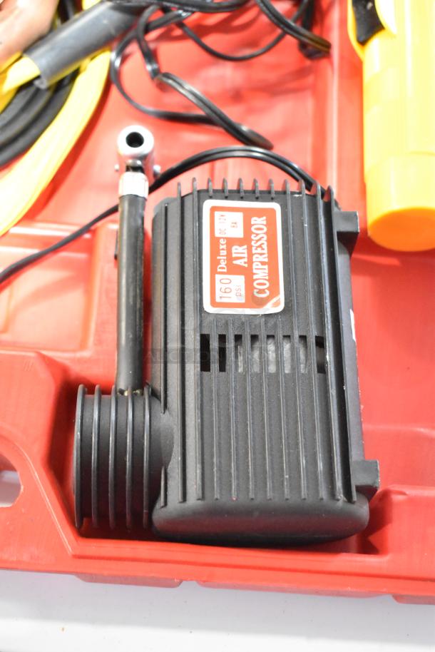 Deluxe air compressor in hard case, 160 psi capacity, black with label indicating DC 12V, 8A. Includes hoses and accessories.