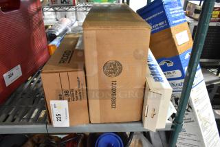 Three brand new items including a Ridgid yoke vise, laundry hamper, and poly pour buckets in original packaging on a shelf.