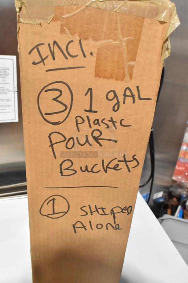 Auction item box labeled "3 1-gal Plastic Pour Buckets," includes new laundry hamper, poly pour buckets, yoke vise.