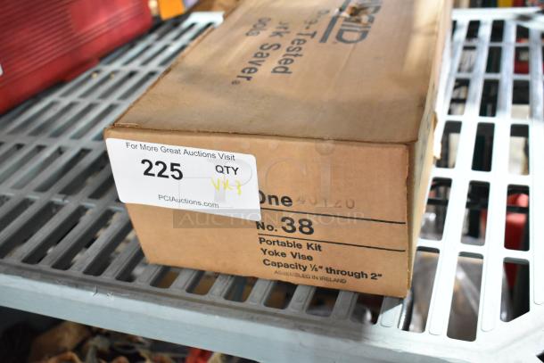 Cardboard box labeled "No. 38 Portable Kit, Yoke Vise." Auction tag: Lot 225, Qty VX3, PCI Auctions. Box on metal rack.