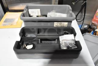 Two gray toolboxes with assorted contents; includes shower/tub parts. Items labeled for identification, in good condition.