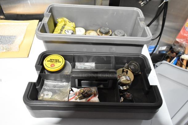 Two gray toolboxes with assorted contents, including grease, fasteners, and clamps, in good condition.
