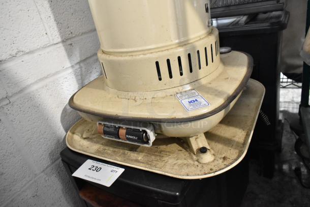 Corona 23-DK Portable Kerosene Heater, cream color, visible wear, with ICC Association label and Duracell battery compartment.