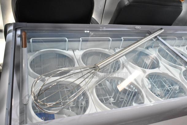 Brand new long-handled whisk with stainless steel wires and handle, placed in unopened packaging, scratch and dent condition.