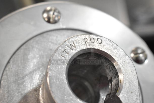 Close-up of a metal item with visible marking "ITW 20D" on its surface, part of a scratch and dent kitchen attachment set.
