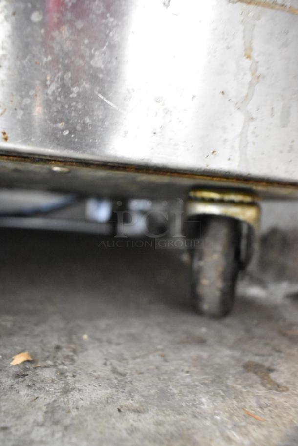 Traulsen ADT132KUT-HHS commercial cooler/freezer on casters, stainless steel finish, visible caster wheel detail.