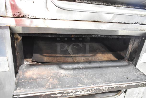 Bakers Pride stainless steel gas-powered single deck pizza oven with cooking stones, used condition, interior view.