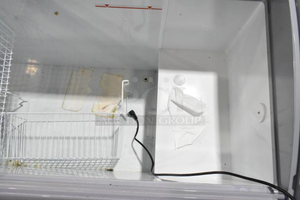 Brand new Avantco 360DFC20HCL ice cream freezer with curved top, interior basket, and commercial casters. Scratch and dent condition.