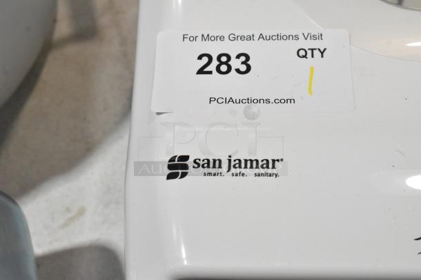 San Jamar Roll Towel Dispenser, brand new with minor scratches, featuring logo and auction label.