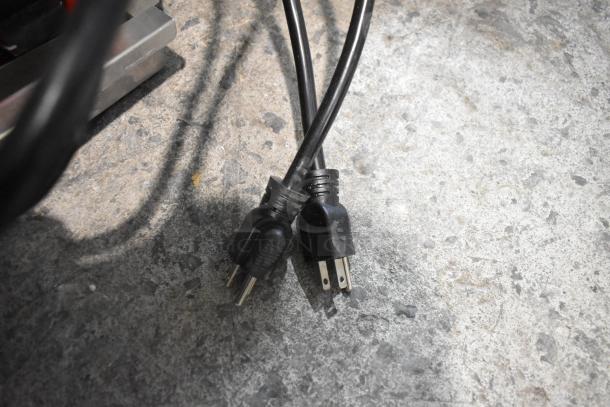 Power cords for BRAND NEW Avantco 177PG400GS Panini Grill, 120V, shown on a concrete surface, indicating dual plug setup.