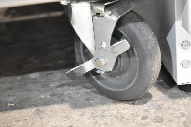 Avantco 177HTESC1836 heated holding cabinet caster, commercial grade, with locking feature, on rough surface.