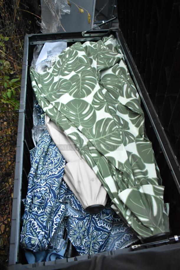 Black deck storage box containing 16 umbrellas with various patterns, including green leaf and blue floral designs.
