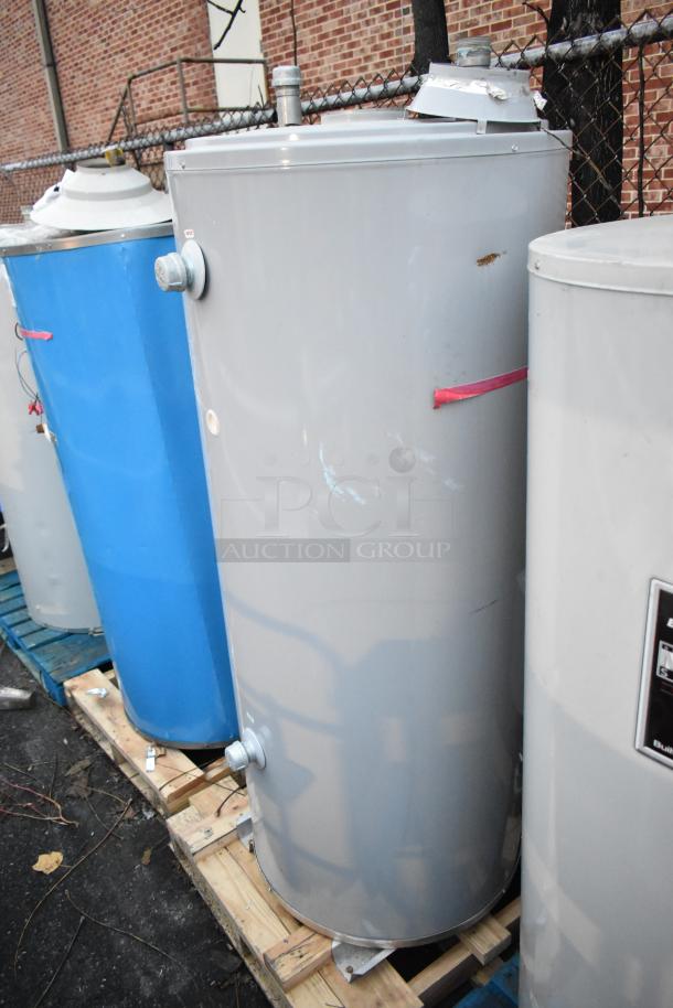 Four tanks including three Bradford White models and a Glacier Opti-stor Heat Recovery System on wooden pallets. Visible wear.