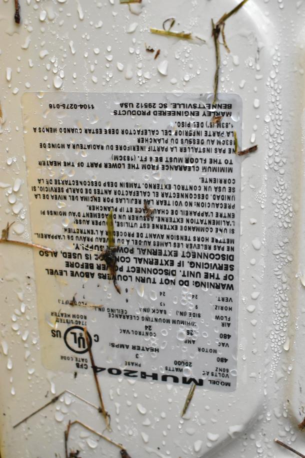 Label on QMark MUH0541 480V unit heater showing specifications and safety warnings, with water droplets.