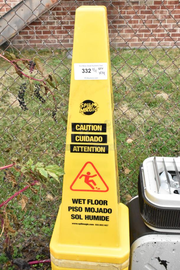 Yellow caution cone displaying "Spill Magic" logo and "Wet Floor" warning in multiple languages. Visible auction tag.