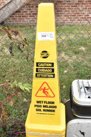 Yellow caution cone displaying "Spill Magic" logo and "Wet Floor" warning in multiple languages. Visible auction tag.
