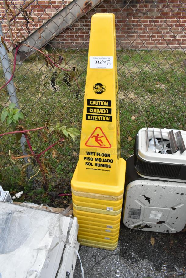 Yellow "Spill Magic" wet floor caution cone, multilingual text, in used condition. Includes 14 cones per bid.